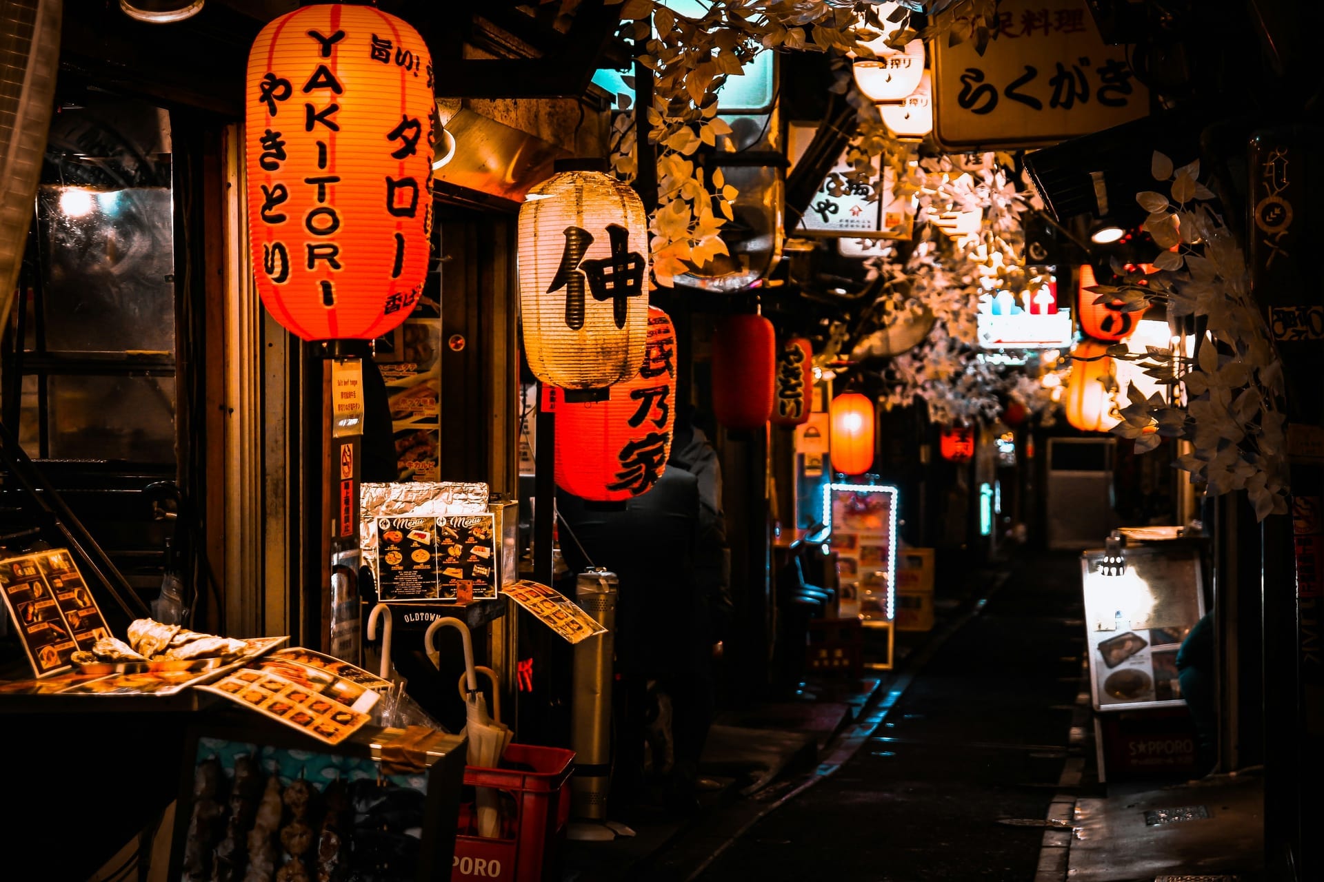 Omoide Yokocho narrow alleyway in Shinjuku lined with glowing red lanterns and small yakitori restaurants at night